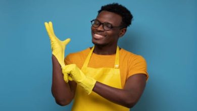 Man on a rubber apron wearing gloves